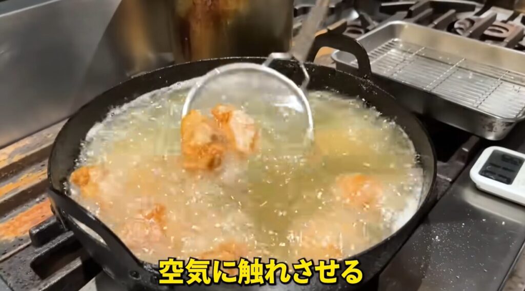 唐揚げを持ち上げて空気に触れさせている